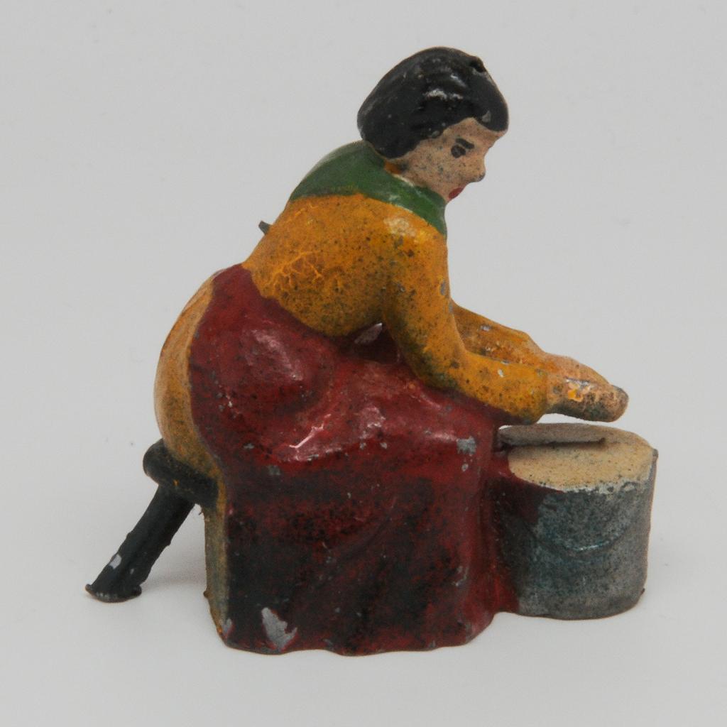 Lead figurine of  woman milking cow, marked FRANCE